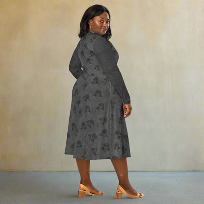 Woman wearing a gray floral dress against a plain background