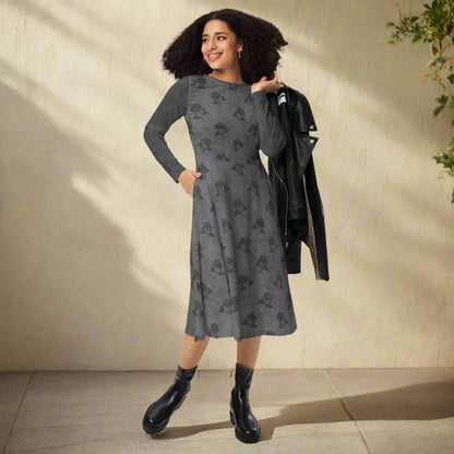 Woman wearing a gray patterned dress with black boots against a beige wall.