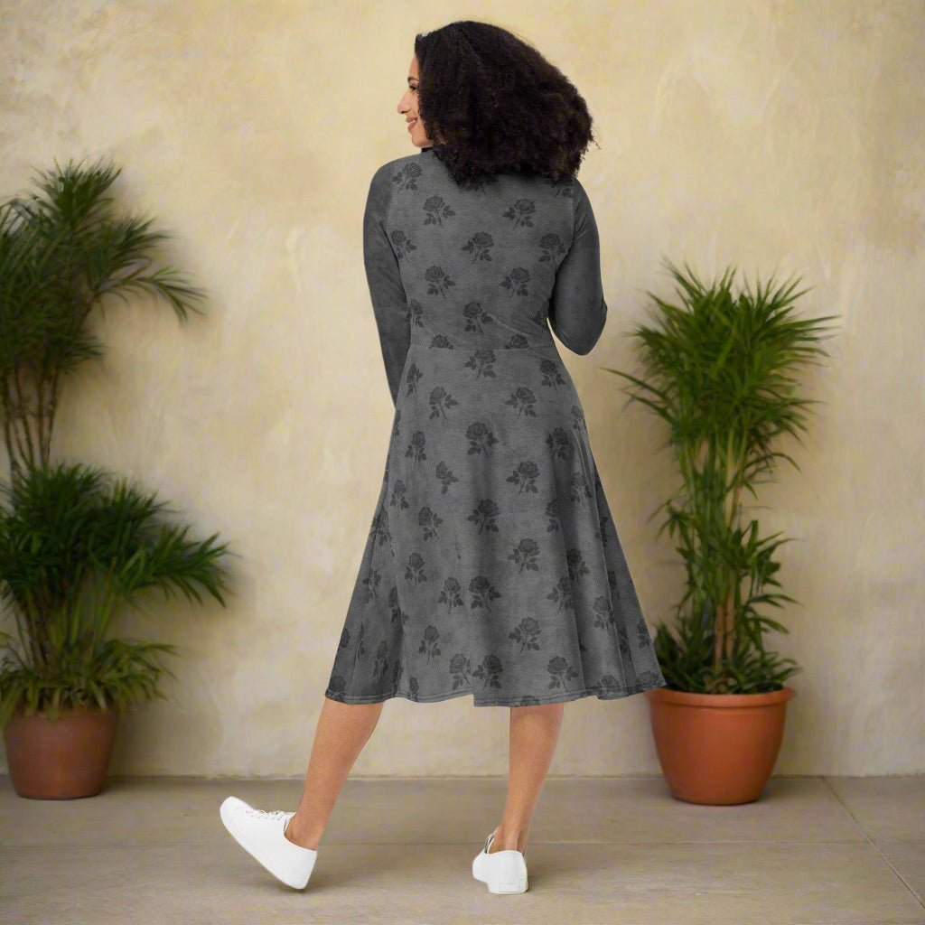 Woman wearing a gray dress with a subtle pattern in a room with plants.