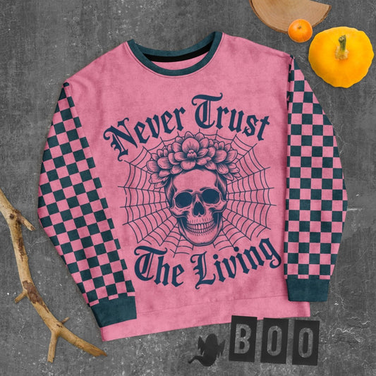 Pink sweater with skull design and text on a textured surface