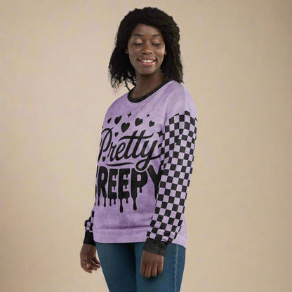 Person wearing a purple sweater with 'Pretty Creepy' text and checkered pattern on a neutral background