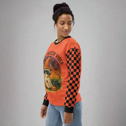 Woman wearing a Halloween-themed orange sweatshirt with checkered sleeves on a neutral background