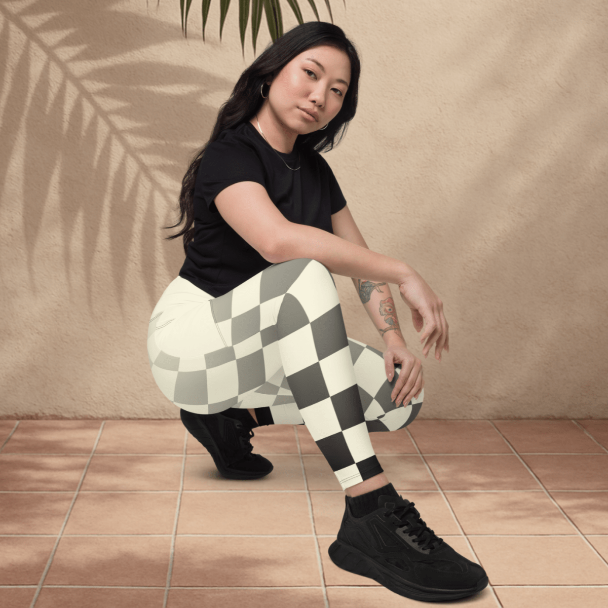 Woman wearing checkered leggings and black shoes on a beige background