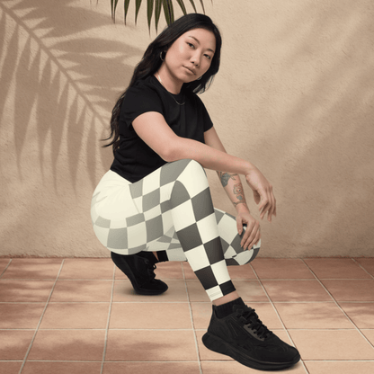 Woman wearing checkered leggings and black shoes on a beige background
