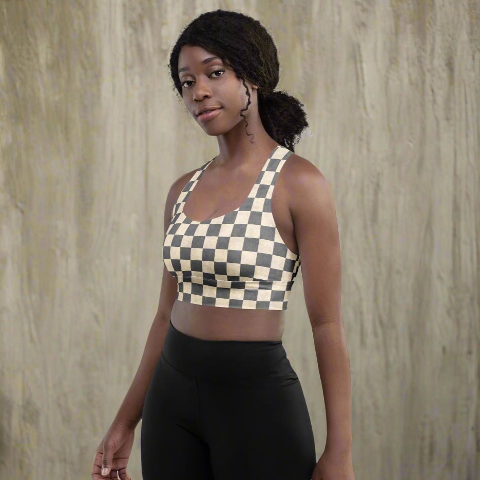 Woman wearing a checkered sports bra and black leggings against a neutral background