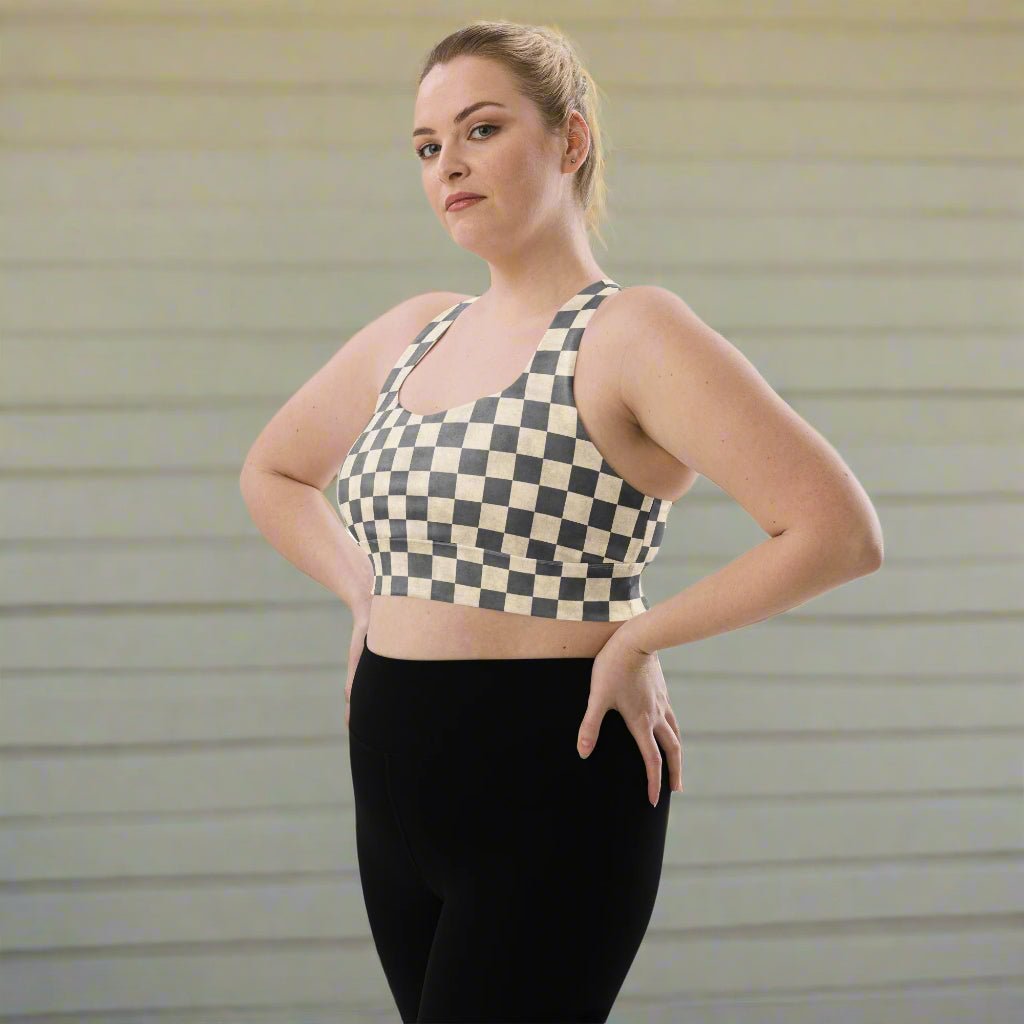 Woman wearing a checkered sports bra and black leggings against a neutral background