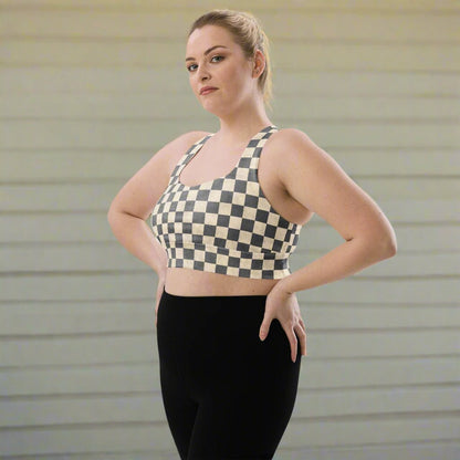 Woman wearing a checkered sports bra and black leggings against a neutral background