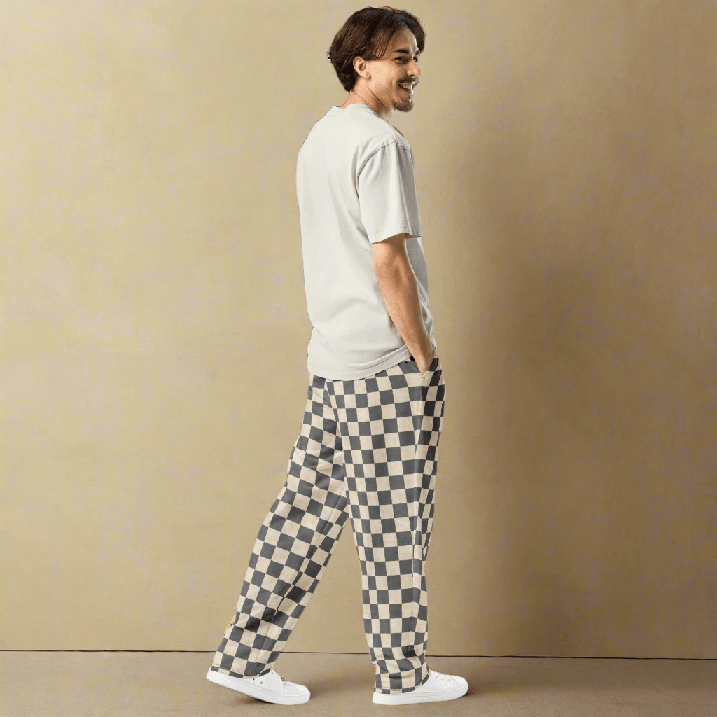 Man wearing a white t-shirt and checkered pants on a beige background