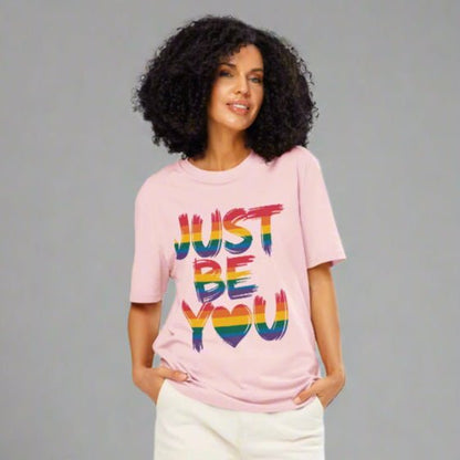 Woman wearing a pink t-shirt with 'JUST BE YOU' text on a white background