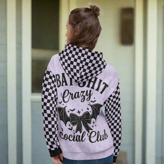 Person wearing a lavender hoodie with text and coquette bat graphics on the back