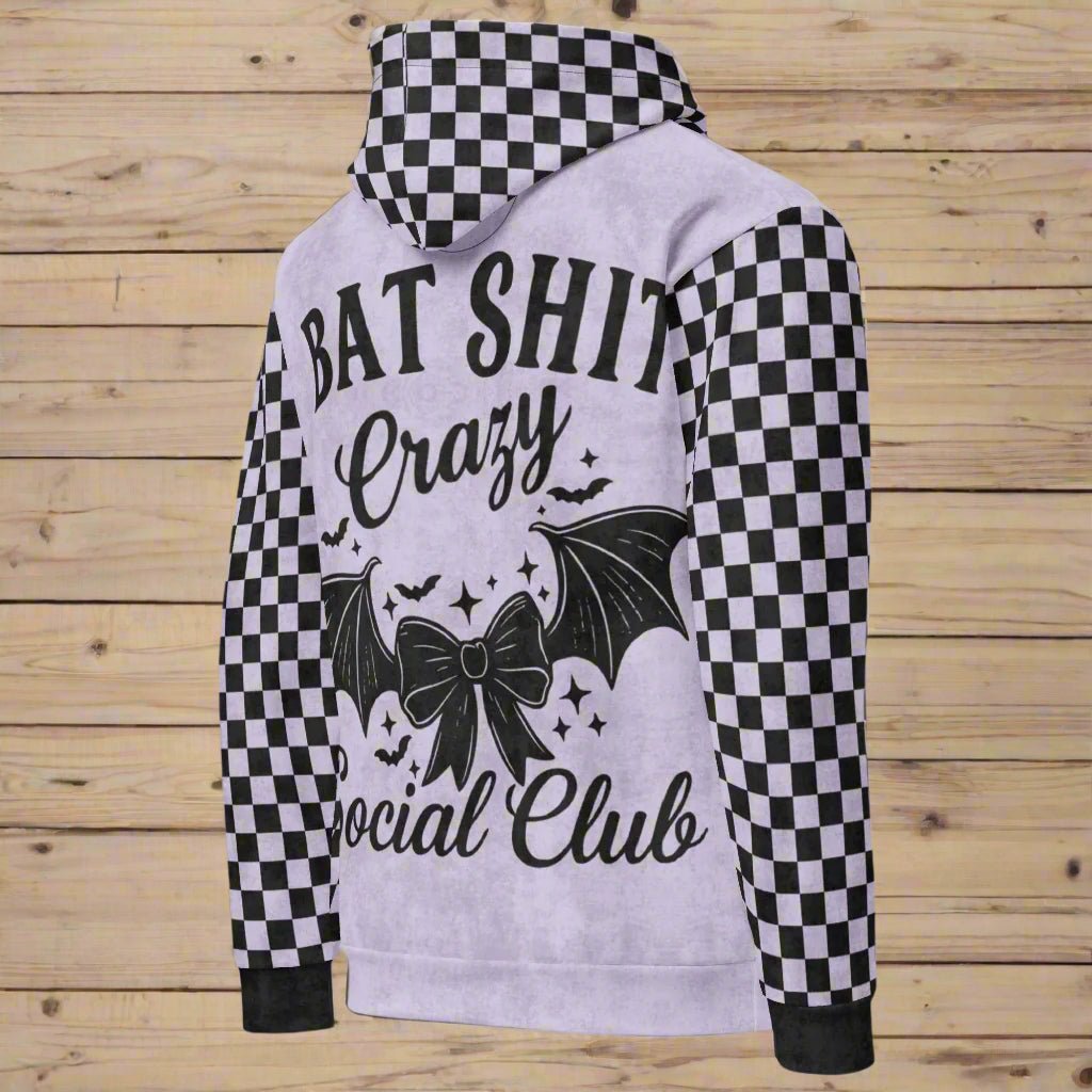 Hoodie with checkered sleeves and graphic design on a wooden background