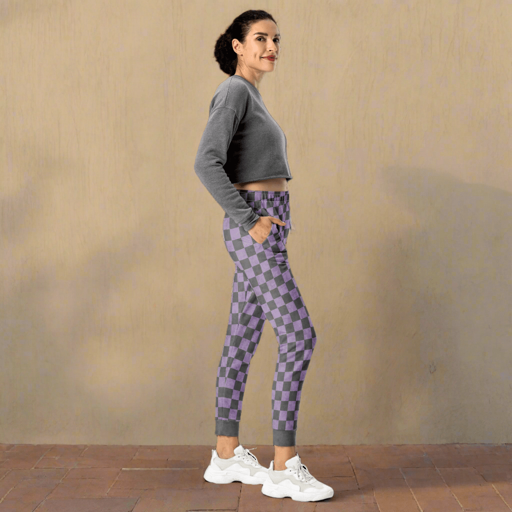Woman wearing gray and purple checkered pants on a neutral background