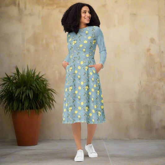 Woman wearing a blue dress with yellow floral pattern on a neutral background