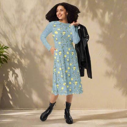 Woman wearing a blue floral dress with black boots against a beige wall.