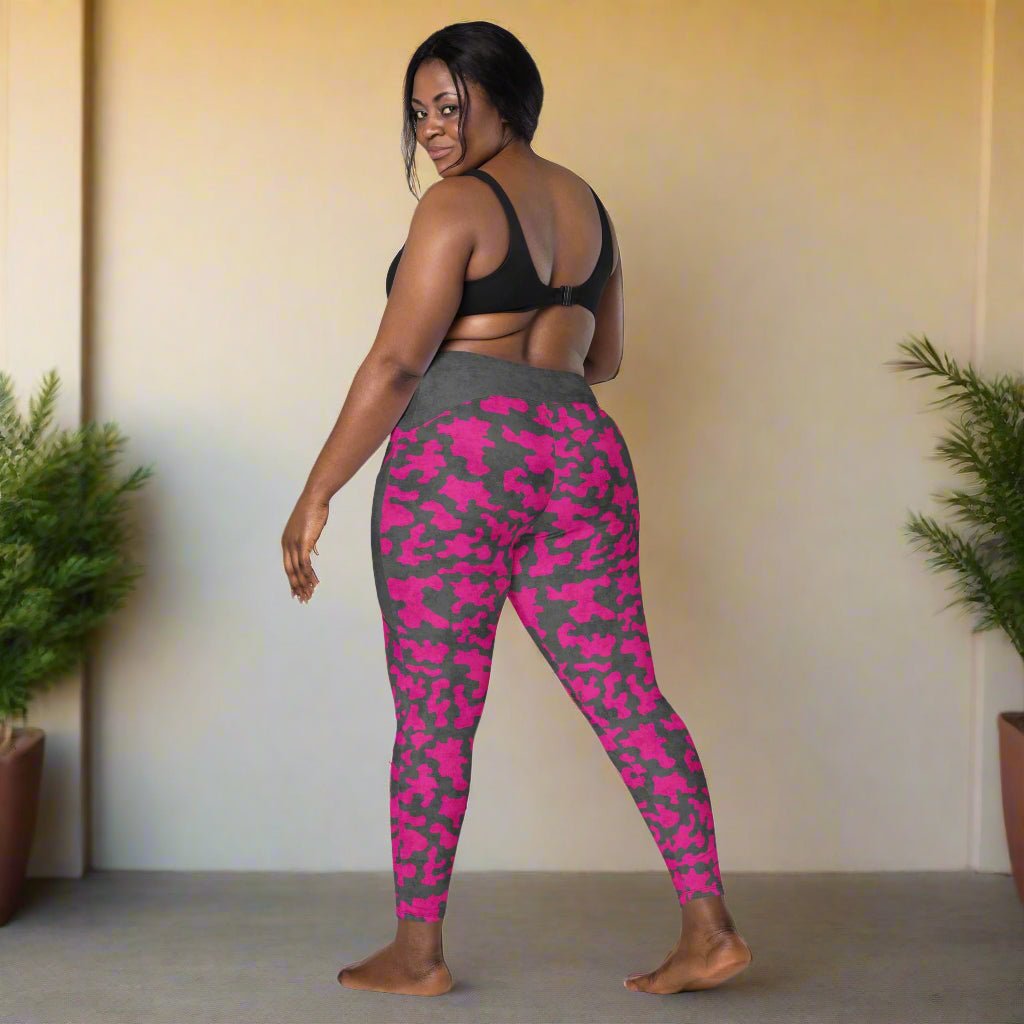 Woman wearing pink and gray camouflage leggings against a neutral background