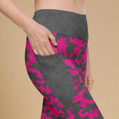 Gray leggings with pink camouflage pattern worn by a person on a beige background