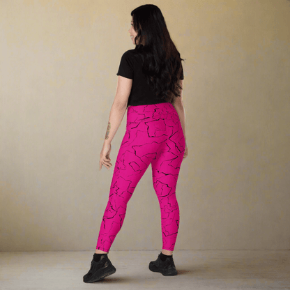 Person wearing bright pink leggings with black patterns on a beige background
