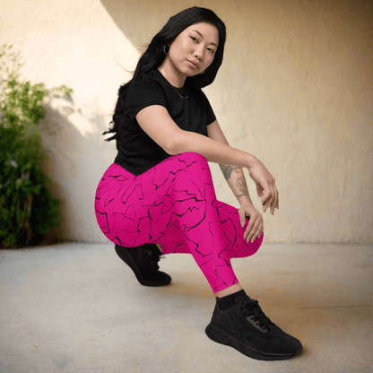 Person wearing pink leggings with black patterns and a black top, sitting on the floor.