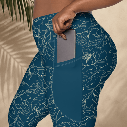 teal leggings with floral pattern worn by a person on a beige background