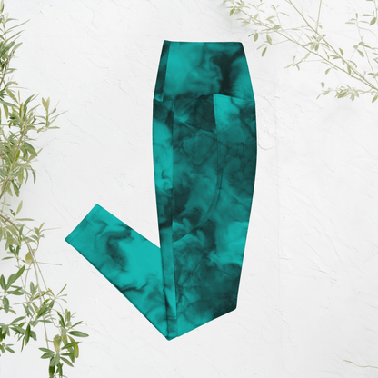 Teal marble-patterned leggings on a white background with green leaves.