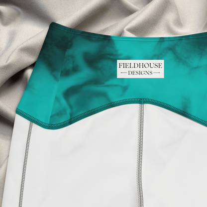 Teal garment with 'Fieldhouse Designs' label on a gray fabric background