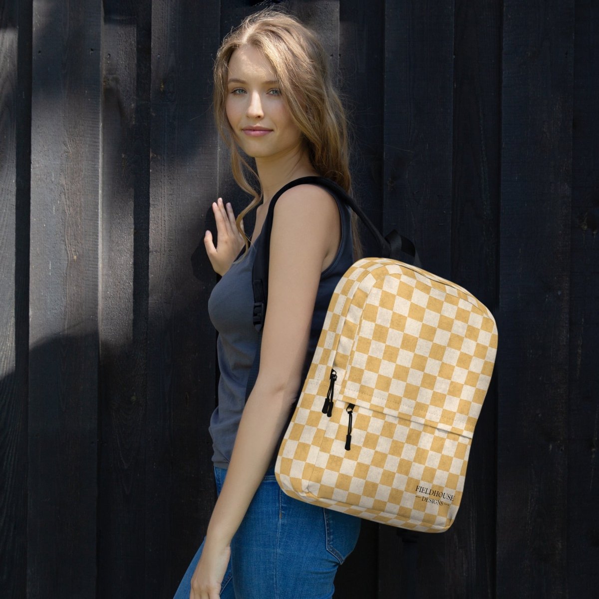 Woman wearing a yellow checkered backpack against a dark background