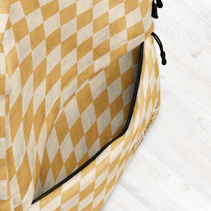 Yellow and white checkered bag with a black zipper on a light wooden surface