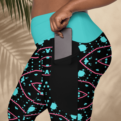 Person wearing black leggings with blue and pink patterns, holding a phone.
