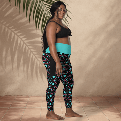 Woman wearing black and teal patterned leggings with a plain background