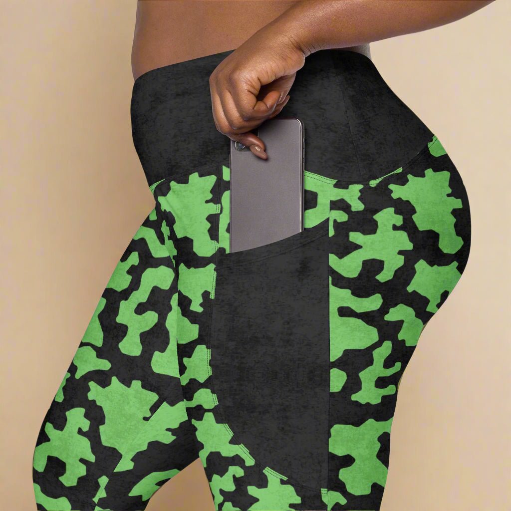 Green and black camouflage leggings with a pocket on a beige background