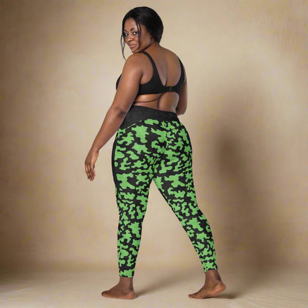 Person wearing green camouflage leggings on a neutral background
