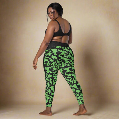 Person wearing green camouflage leggings on a neutral background