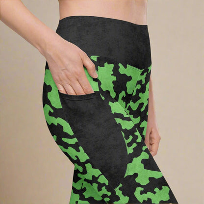Black leggings with green camouflage pattern worn by a person on a beige background