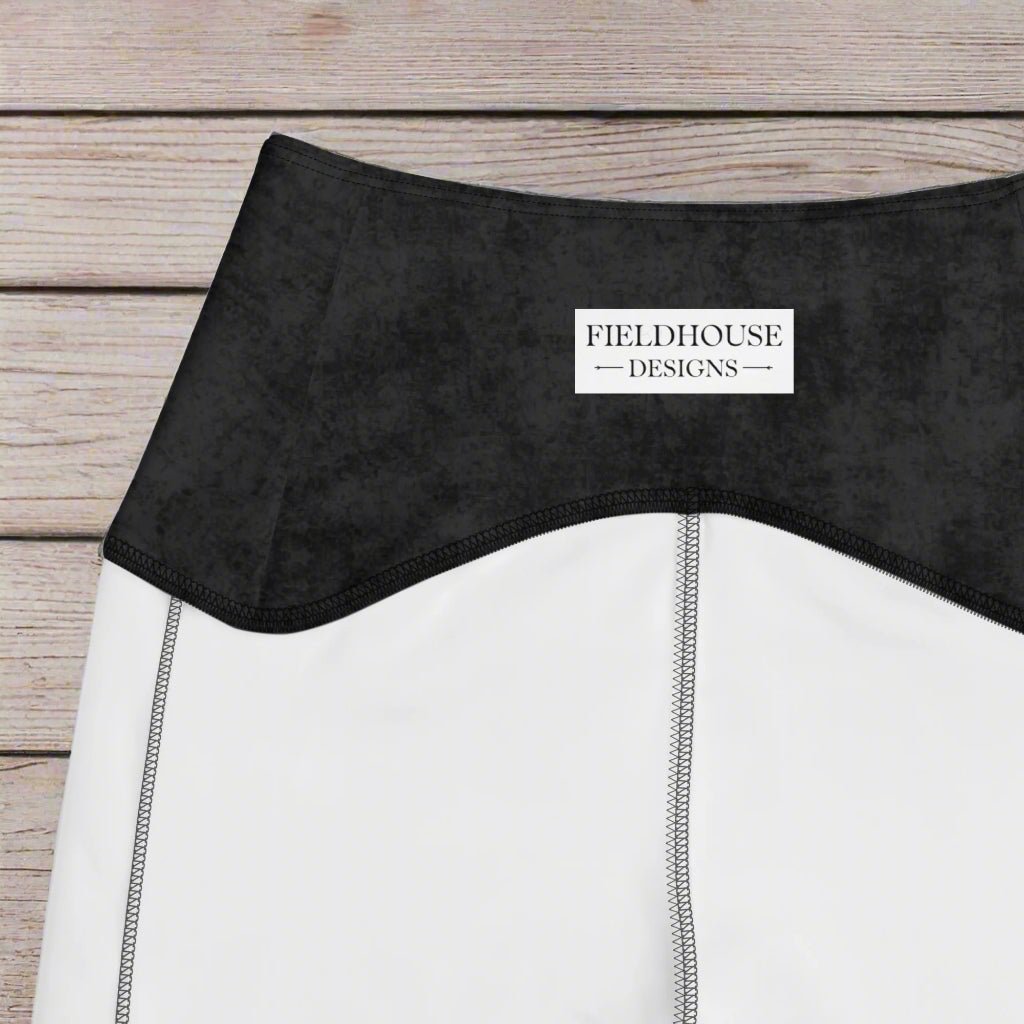 Close-up of a black waistband with 'Fieldhouse Designs' label on a wood background