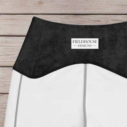 Close-up of a black waistband with 'Fieldhouse Designs' label on a wood background