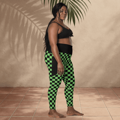 Woman wearing black and green checkered leggings against a beige wall.