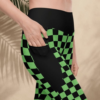 Person wearing black leggings with green and black checkered pattern on a beige background