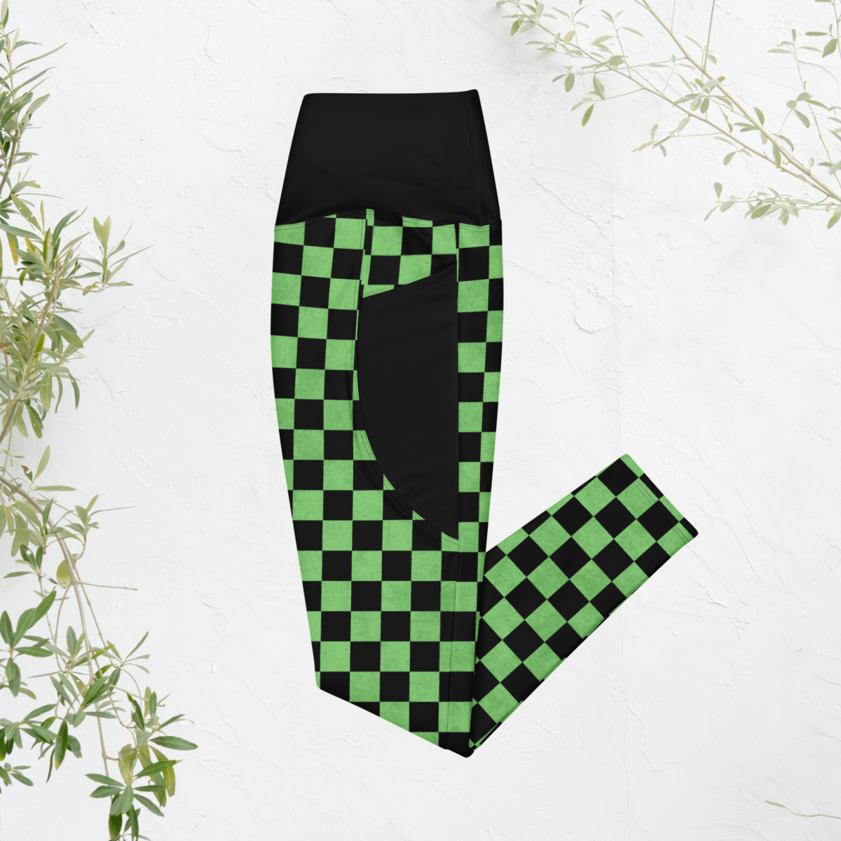 Green and black checkered leggings on a white background with plant decorations.