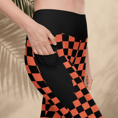 Person wearing black and orange checkered pants on a beige background