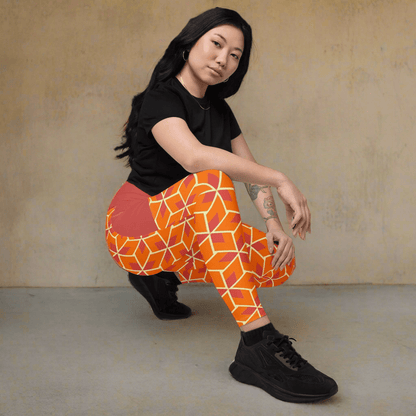 Person wearing orange geometric leggings and black shoes on a beige background