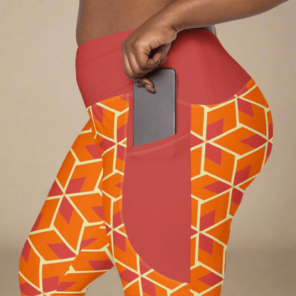 Orange geometric-patterned leggings with a pocket holding a phone on a beige background