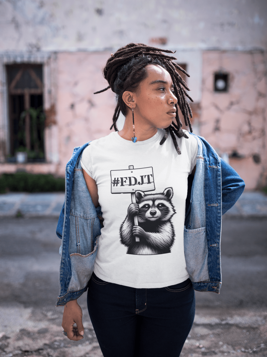Person wearing a white t-shirt with a raccoon graphic and '#FDJT' text, standing outdoors.
