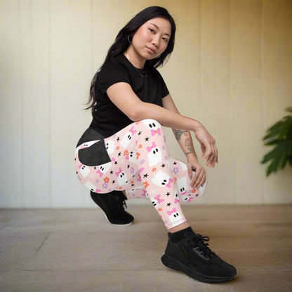Person wearing a black top and colorful leggings with ghost and star pattern on a neutral background