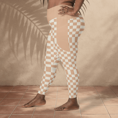 Person wearing checkered leggings standing against a beige wall.