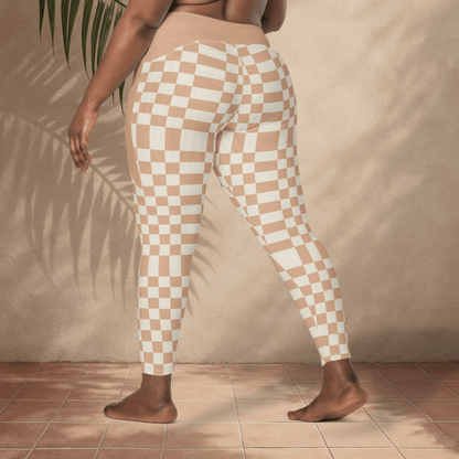 Person wearing checkered pants standing against a beige wall.