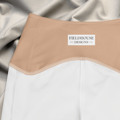 peach waistband with 'Fieldhouse Designs' label on a white garment against a beige fabric background