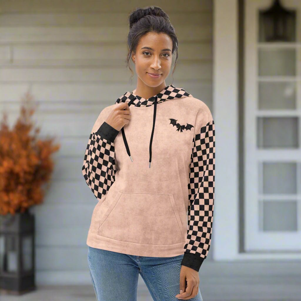 Woman wearing a beige hoodie with checkered sleeves