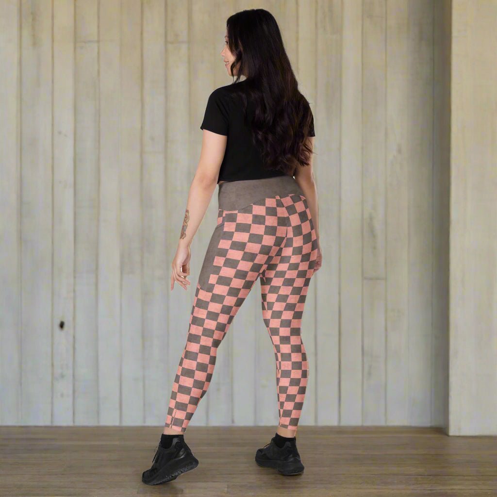 Woman wearing pink and gray checkered leggings on a neutral background