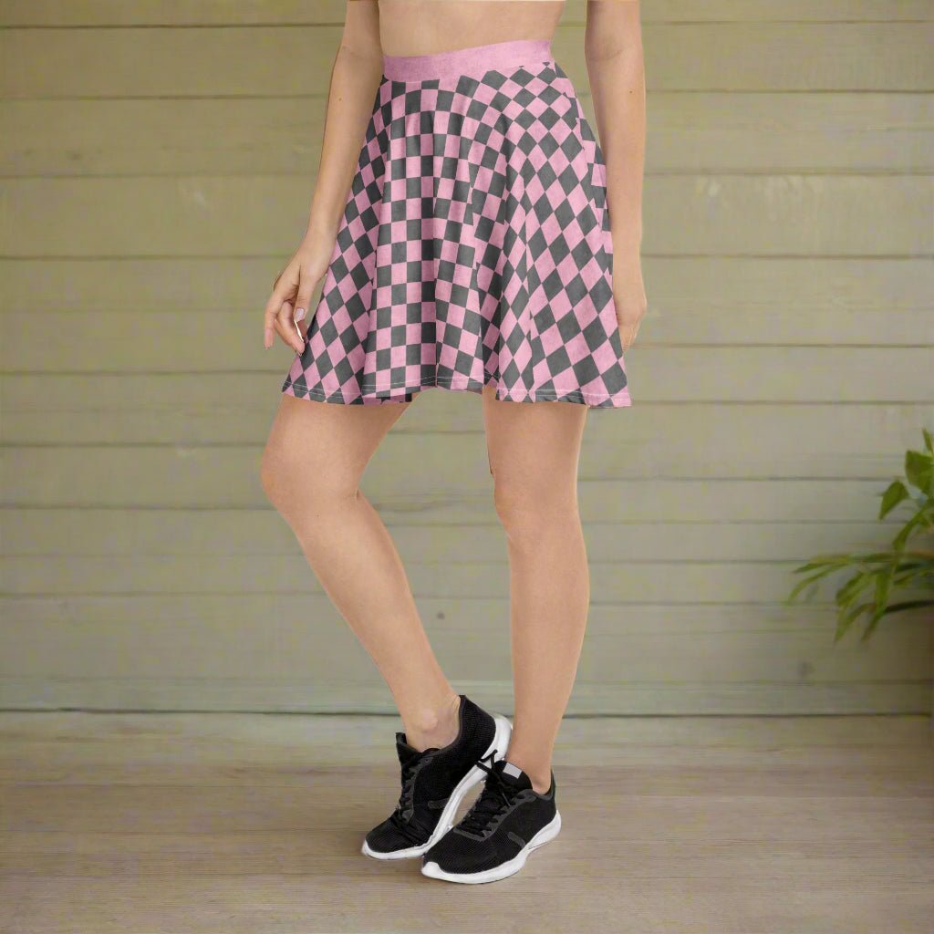 Person wearing a pink and gray checkered skirt with black sneakers on a wooden floor.
