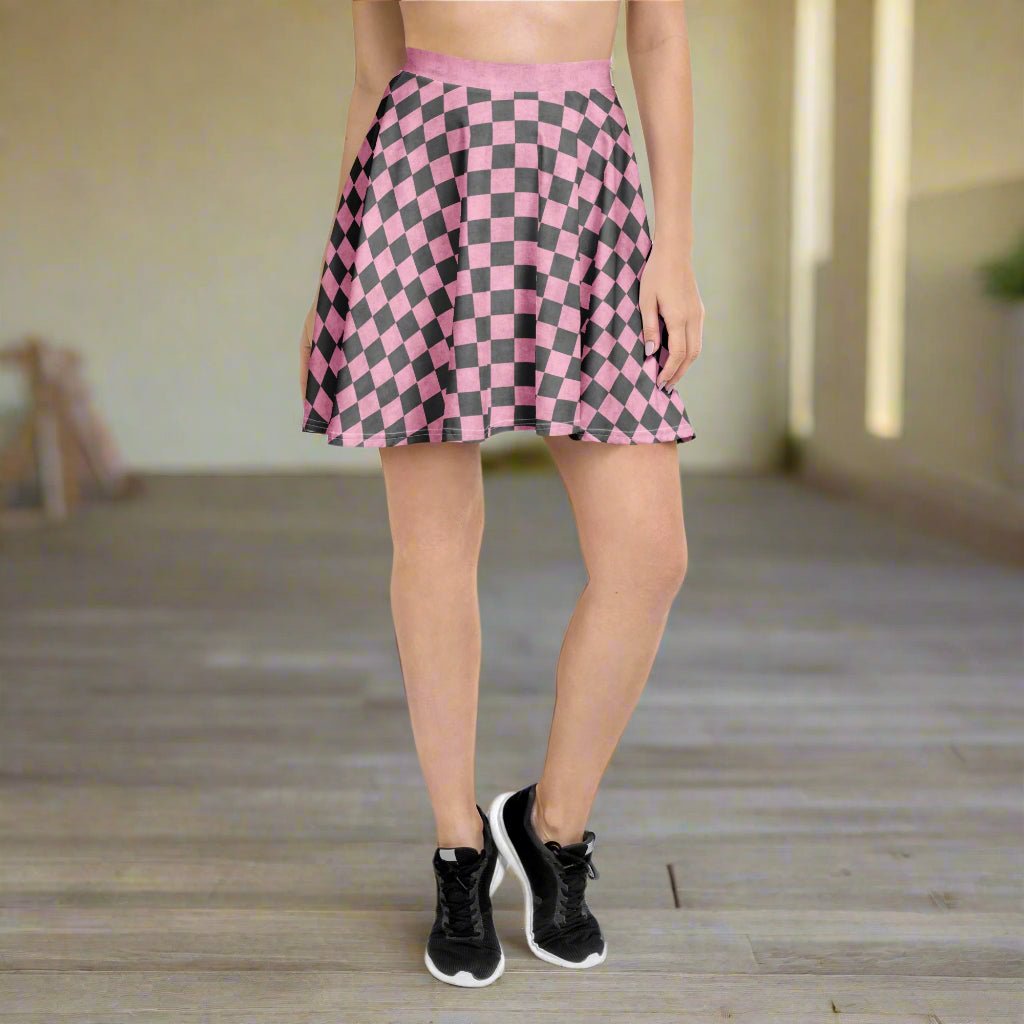 Person wearing a pink and gray checkered skirt with black sneakers on a wooden floor.